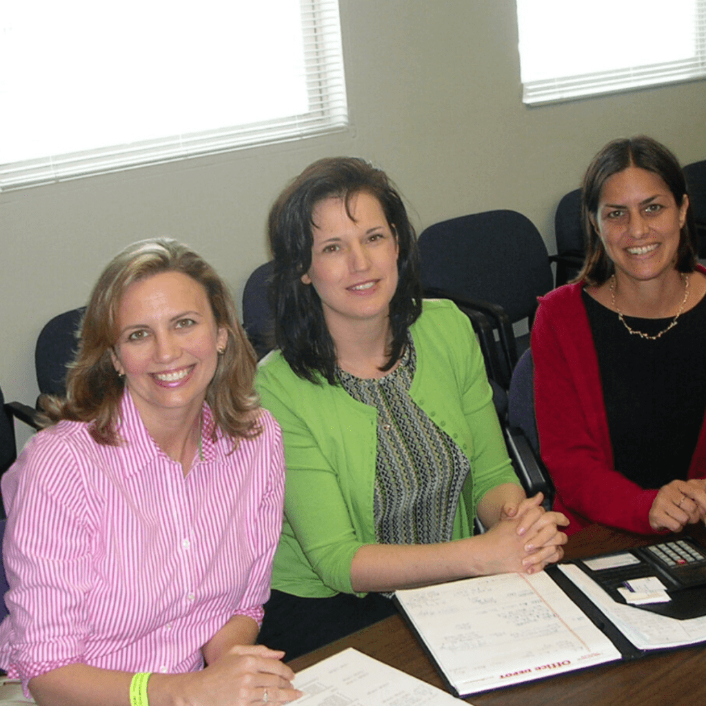 photo of Ann Marie King, Kimmber MacGibbon, Marlena Fejzo sitting at a table in 2005 discussing research.